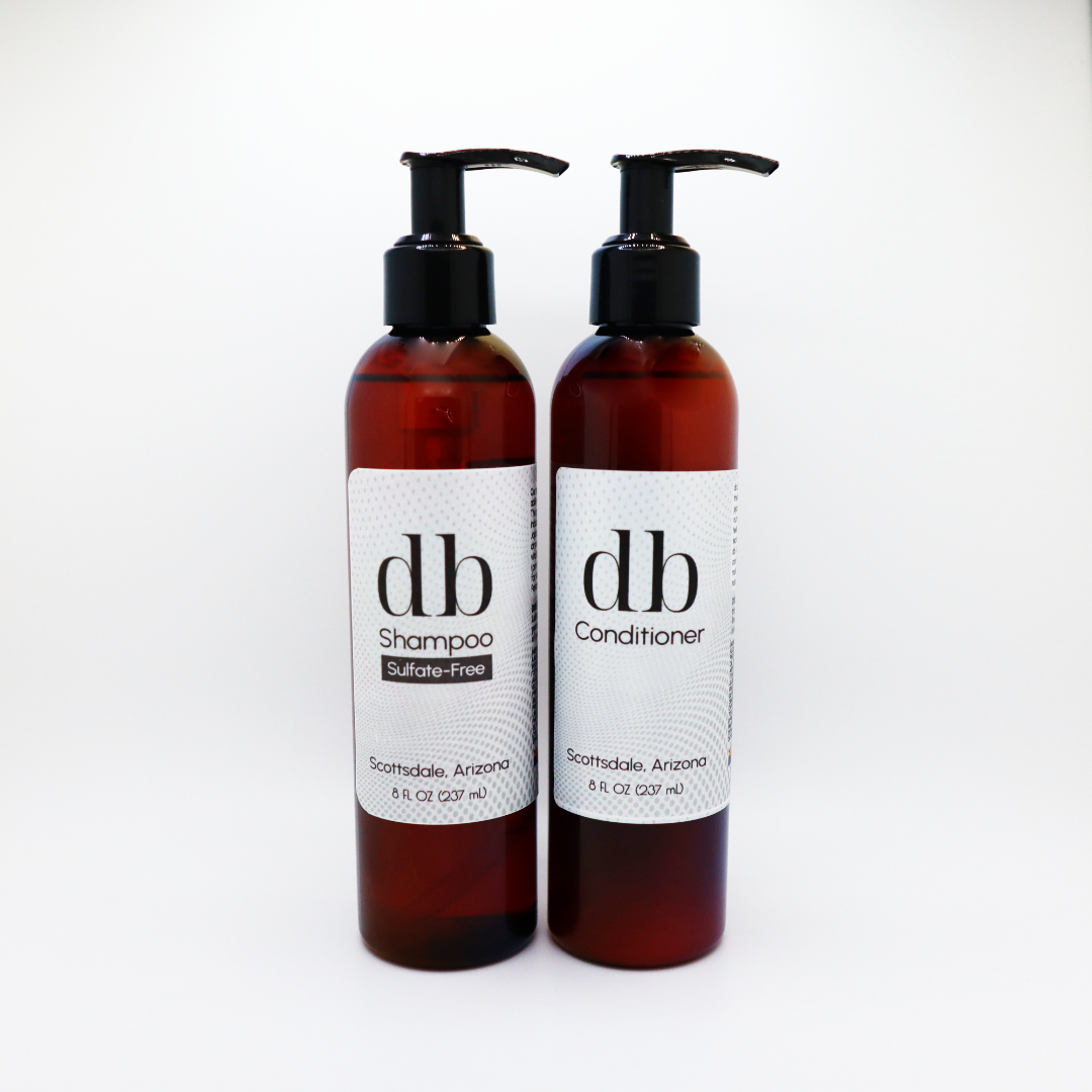 Shampoo and Conditioner product photo. Two amber pump bottles against white background.